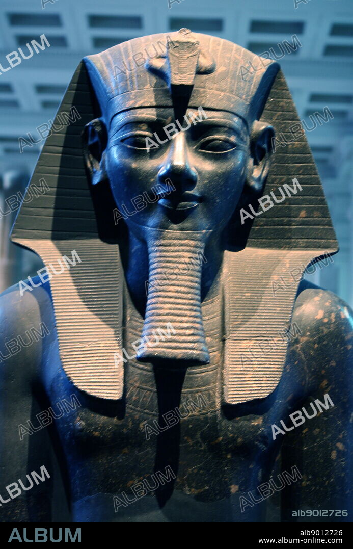Statue of king Amenhotep III. 18th Dynasty, about 1400 BC from Thebes The king is represented in classic pose and dress. Seated on a throne with both hands flat on the knees, her wears a nemes-headcloth, false beard and short kilt, which fitted with a ceremonial bull's tail, shown between the leg. The king's names are inscribed on the front and back of the throne and on the belt of the kilt.