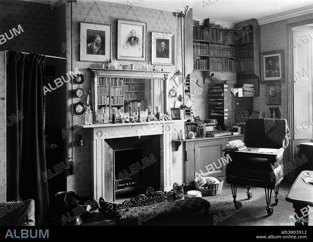 Interior of Charles Darwin's study, showing mantlepiece and Darwin's chair on wheels. Down House in Downe, Kent, is where Charles Darwin worked for 40 years, wrote On the Origin of Species, and died in 1882. This photograph is from 1932. Darwin (1809-1882) was an English naturalist and geologist. He established that all species of life have descended over time from common ancestors, and in a joint publication with Alfred Russel Wallace introduced his scientific theory that this branching pattern of evolution resulted from a process that he called natural selection, in which the struggle for existence has a similar effect to the artificial selection involved in selective breeding.