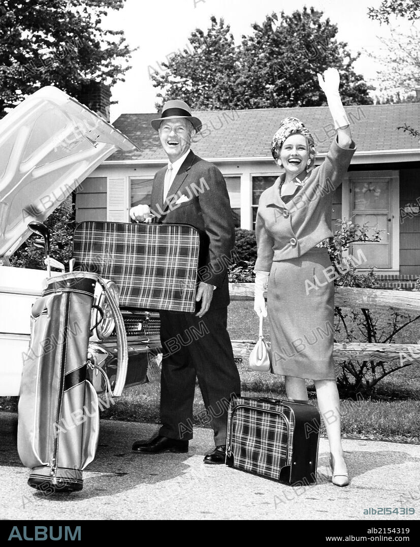 Mature couple loading car trunk for a trip.
