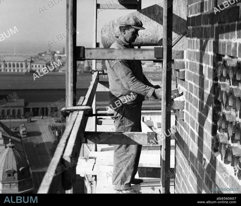 Murare på byggnadsställning på hög höjd vid reparation av . fasaden på S:t Petri kyrka i Malmö 1938.. Foto: Sydsvenskan / IBL Bildbyrå.