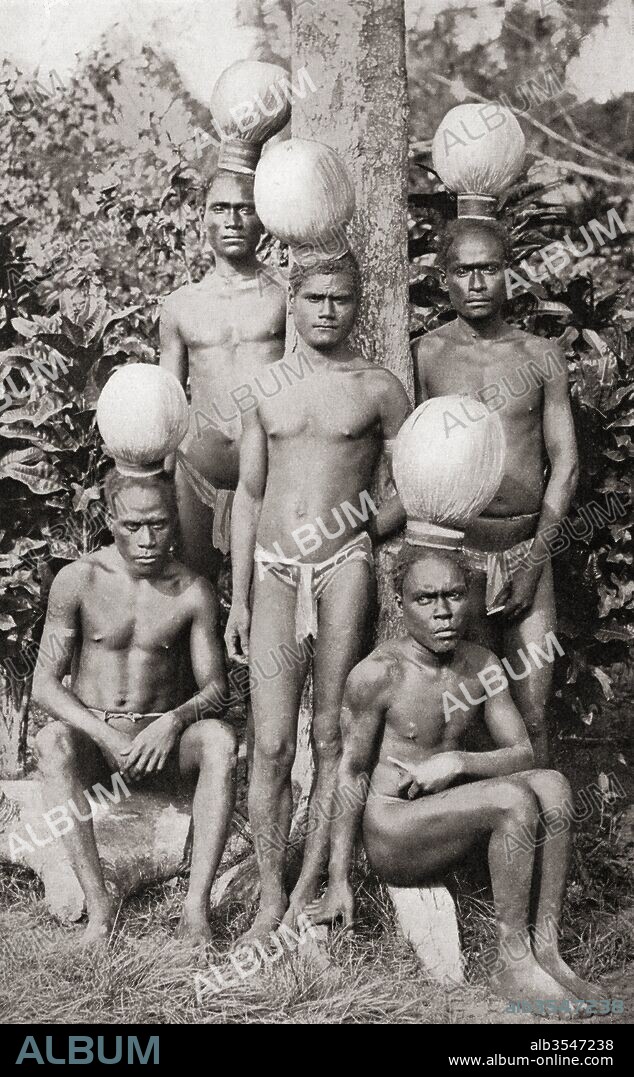 Initiation on Bougainville Island, Papua New Guinea, Melanesia as shown in a 19th century photograph. Four or five youths were chosen and taken into a hut to do various forms of labour, learn the tribal rules and had to always wear the curious hats shown in the picture. When their hair filled the hat the period of seclusion was over. From Customs of The World, published c.1913.