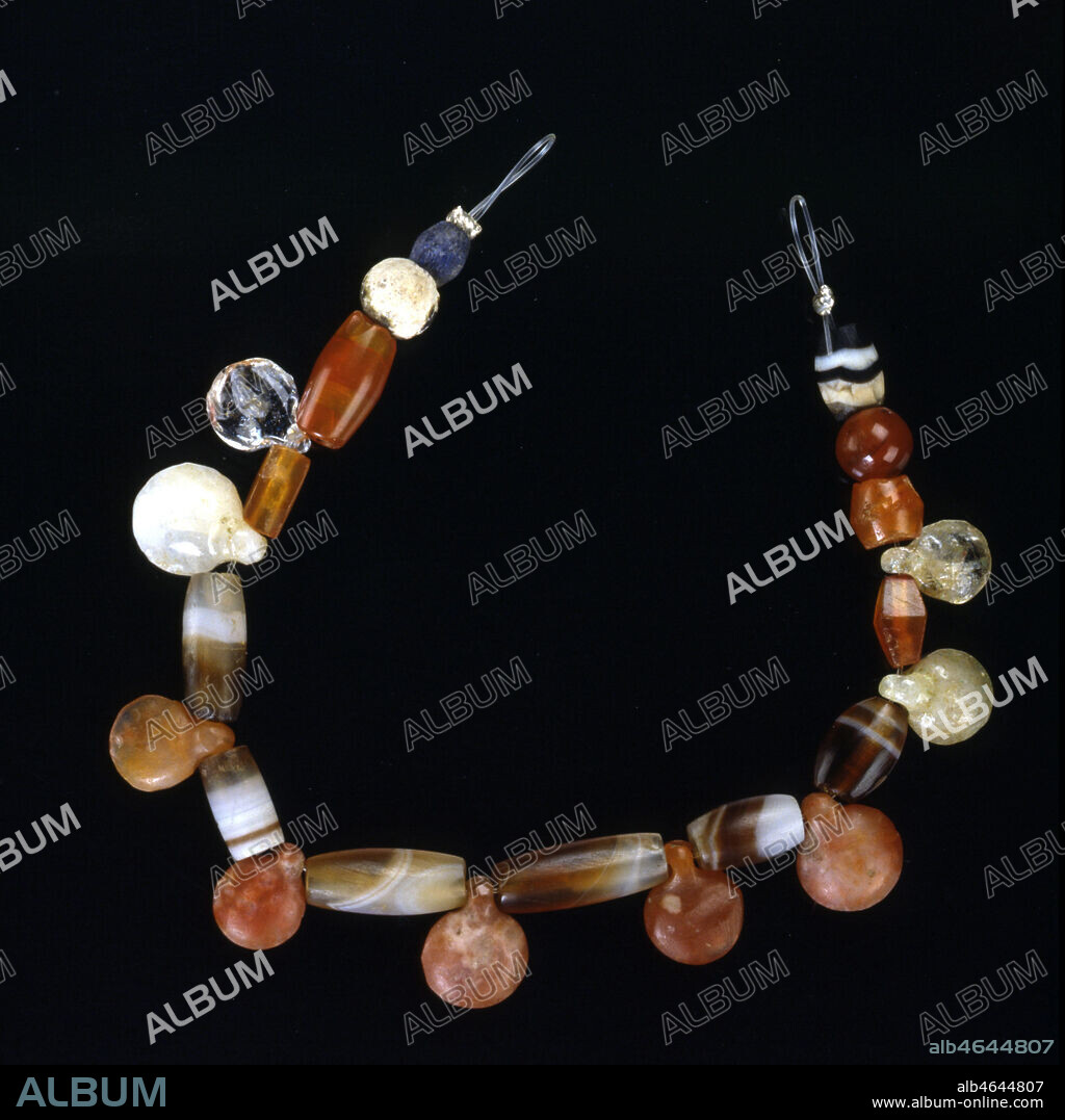 Perles montées en collier: agate, cornaline, cristal de roche, lapis-lazuli. Début du 2ème mill. av. JC. Provient de la ville de Tello, état sumérien de Lagash, au sud de l'actuel Iraq. Ce collier comporte des petits pendentifs lenticulaires à bélière et certains sont taillés dans du cristal de roche d'une exceptionelle pureté. Credit : Larrieu-Licorne/Kharbine-Tapabor.