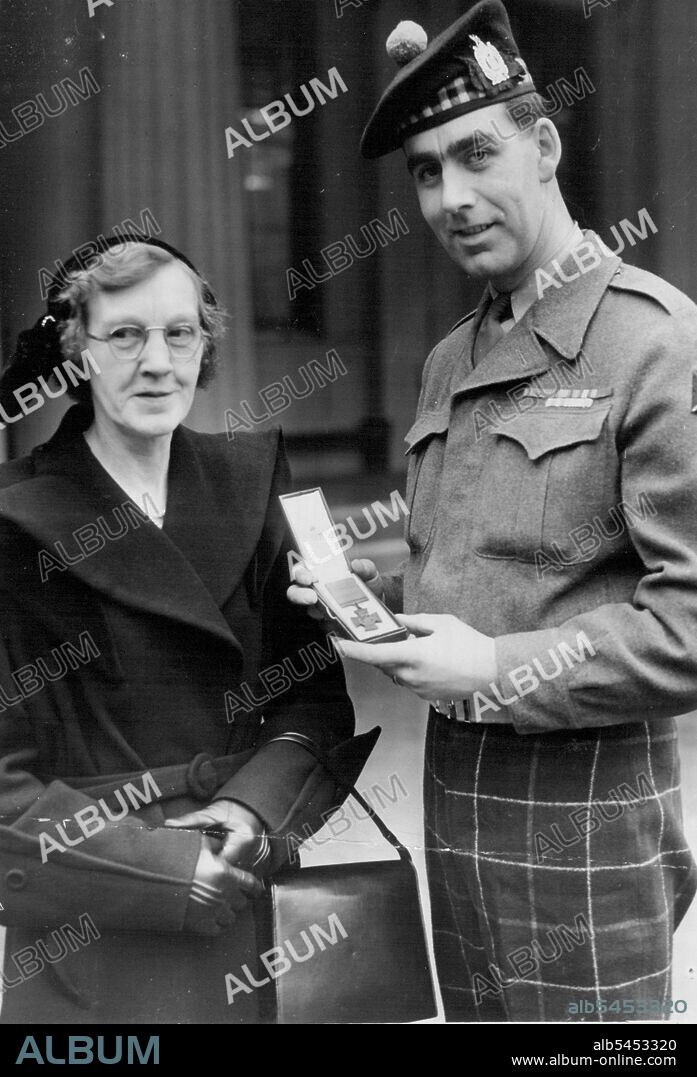 Proudest Mother of All Speakman Presented With V.C. At Palace -- A proud Bill Speakman of the Black Watch shows his mother the Victoria Cross presented to him when the Queen held her first Investiture at Buckingham Palace to-day. The 24-year-old solider of Altrincham, Cheshire, won the decoration in Korea. February 27, 1952.