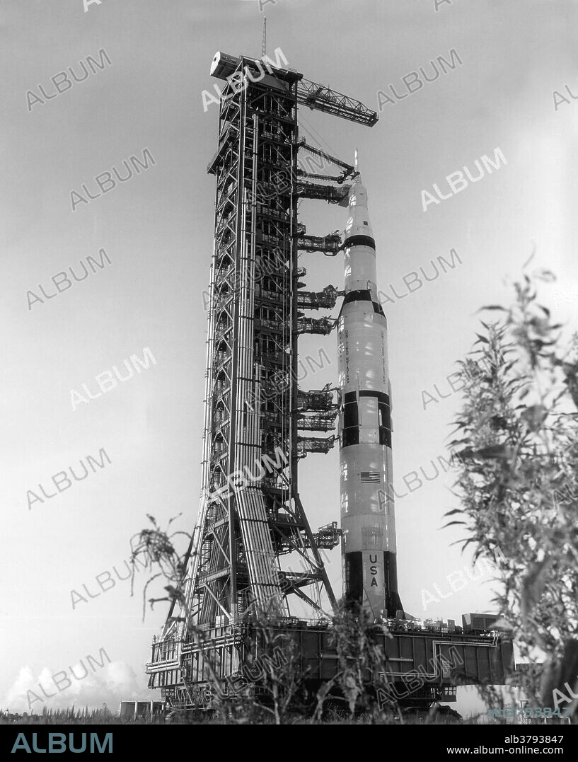 Apollo 4, the first space vehicle in NASA's Apollo/Saturn V program, leaves the Vehicle Assembly Building for erection at Pad A of Complex 39. The 364 foot, three stage rocket and spacecraft, weighing 6,286,000 pounds when fueled, is being transported on the mobile launcher to the launch pad. The transporter moves over the specially constructed crawlerway designed to support loads of approximately 18 million pounds. August 26, 1967.