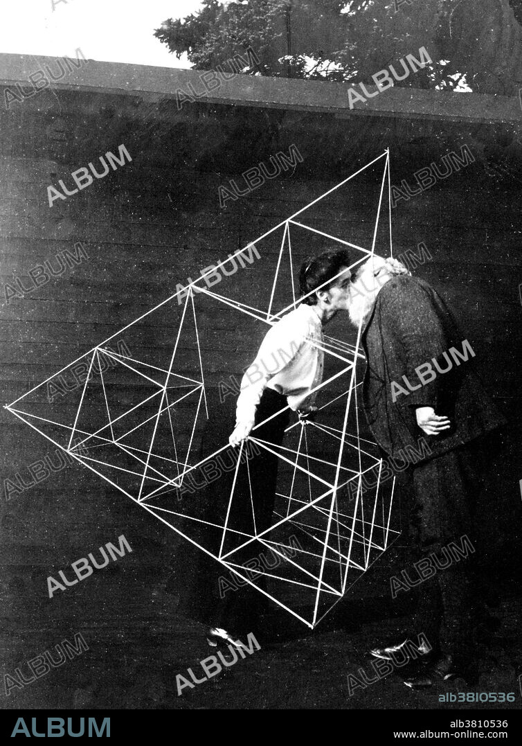 Bell kissing his wife Mabel, who is standing in a tetrahedral kite, Baddeck, Nova Scotia. Alexander Graham Bell (March 3, 1847 - August 2, 1922) was a Scottish-American speech therapist and inventor of the telephone. Bell followed his father and grandfather into the speech therapy profession, but also studied sound waves and the mechanics of speech. By 1871, he had moved to the USA, becoming professor of vodal physiology in Boston. In 1876, he patented the telephone and founded what has become the AT&T company. In later years he made many improvements to the telephone, worked with Langley and Curtis on flying machines, and founded the journal "Science." He died of complications arising from diabetes in 1922 at the age of 75. Mabel Gardiner Hubbard (November 25, 1857 - January 3, 1923) was his wife. Folklore held that Bell undertook telecommunication experiments in an attempt to restore her hearing which had been destroyed by disease close to her 50th birthday. No photographer credited, October 16, 1903.