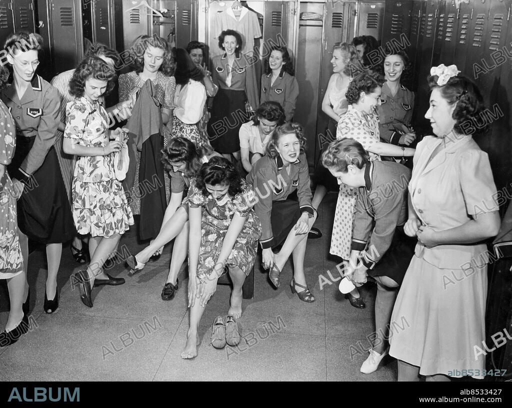 Orig. bildtext... GOING HOME... Here is a locker room scene as the N.Y.S.E. girls prepare to go home at the end of their day's work. A few are feeling the pangs of aching feet after a day of runing from post to pillar, but the chances are they'll be out dancing tonight with the favorite serviceman. Anm. Ansiktsuttryck Ömma fötter Ben Klänningar Arbetskläder Plåtskåp New York Stock Exchange Börsen CD204 sites: NEW YORK;USA Bilden får endast användas i programrelaterade sammanhang. Vid publicering skall fotografens namn, SVT samt programmets titel alltid anges.