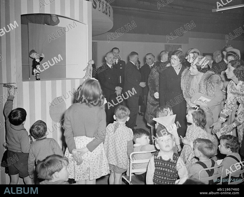 Ideal Homes On Show Today. A wealth of attraction for the homelover - unequalled since before the war is presented at the 25th Daily Mail Ideal Homes Exhibition, which opens this evening (Tuesday) at Olympia, London. Visitors will welcome the re-introduction of free treats and free gifts at many of the stands - another pre-war touch. Exhibits include six full-sized and fully-furnished dwellings, an alluminium bungalow, and intriguing collection of historical timepieces and a playland where kids may be left with a host of playthings while their parents are touring the exhibition. Picture Shows: "It lights and it writes" Mammoth propelling pencil cum lighters are used the emphasise one of the British products displays at the Exhibition. Picture shows: Her Majesty the Queen and Princess Margaret are amused by the Punch and Judy show in the Nestle Playland at the Exhibition. The little boy in the foreground couldn't care less. March 2nd 1948.