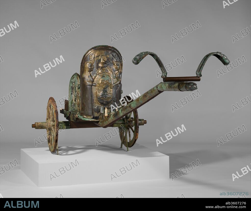 Bronze chariot inlaid with ivory. Culture: Etruscan. Dimensions: total H. 51 9/16 in. (130.9 cm)
length of pole  82 1/4 in. (209 cm). Date: 2nd quarter of the 6th century B.C..
Scenes from the life of the Greek hero Achilles
The Acquisition
In 1902, a landowner working on his property accidentally discovered a subterranean built tomb covered by a tumulus (mound). His investigations revealed the remains of a parade chariot as well as bronze, ceramic, and iron utensils together with other grave goods. Following the discovery, the finds passed through the hands of several Italian owners and dealers who were responsible for the appearance of the chariot and related material on the Paris art market. There they were purchased in 1903 by General Luigi Palma di Cesnola, the first director of The Metropolitan Museum of Art. The Monteleone chariot is the best preserved example of its kind from ancient Italy before the Roman period. The relatively good condition of its major parts--the panels of the car, the pole, and the wheels--has made it possible to undertake a new reconstruction based on the most recent scholarship. Moreover, some of  the surviving ivory fragments can now be placed with reasonable certitude. The other tomb furnishings acquired with the chariot are exhibited in two cases on the south wall of this gallery.
The Form and Function of the Chariot
Chariots originated in the Ancient Near East during the early second millennium B.C. and spread westward through Egypt, Cyprus, and the Greek world. In the predominant early  type, the car consisted essentially of a platform with a light barrier at the front.
On the Italian peninsula, the largest number of chariots come from Etruria and the surrounding regions. They are datable between the second half of the eighth and the fifth centuries B.C. and represent several varieties. None seems to have been used for fighting in battle. Most came to light in tombs; after serving in life, they were buried with their owners, male and also female. The Monteleone chariot belongs to a group of parade chariots, so called because they were used by significant individuals on special occasions. They have two wheels and were drawn by two horses standing about forty-nine inches (122 centimeters) apart at the point where the yoke rests on their necks. The car would have accommodated the driver and the distinguished passenger. The shape of the car, with a tall panel in front and a lower one at each side, provided expansive surfaces for decoration, executed in repoussé. The frieze at the axle, the attachment of the pole to the car, and the ends of the pole and yoke all have additional figural embellishment.
The Materials of the Chariot
Although none of the substructure of the original chariot survives, except in one wheel, much information can be gleaned from details on the bronze pieces, other preserved chariots, and ancient depictions of chariots. Note that a chariot is represented on the proper left panel of the car. The preserved bronze elements of the car were originally mounted on a wooden substructure. The rails supporting the three main figural panels were made from a tree such as a yew or wild fig. The floor consisted of wooden slats. The wooden wheels were revetted with bronze, an exceptional practice probably reserved only for the most elaborate chariots. A bit of the preserved core has been identified as oak. The tires are of iron. The sections of the pole were mounted on straight branches. A major component of the original vehicle was leather applied to the wooden substructure. The connection of the pole to the car would have been reinforced by rawhide straps gathered beneath the boar's head, and the yoke would have been lashed to the pole. The upper end of the pole shows traces of the leather bands. In addition, all of the horses' harness was of leather. Moreover, rings of pigskin with the fat attached helped reduce friction between the moving parts of the wheels. The Monteleone chariot is distinguished not only by the extraordinary execution of the bronze panels but also by the inclusion of ivory inlays. The ivories, from both elephant and hippopotamus, are so fragmentary that only the tusks of the boar and the finials at the back of the car have been placed in their original positions. The remaining pieces are exhibited in a case on the south wall. A series of long narrow strips served as edging, perhaps around the panels of the car or on the underside of the pole. It is possible that other fragments filled the spaces between the figures in the central panel of the car. A major question concerning these adjuncts is the method of their attachment, requiring the use of an adhesive. Another question is whether the ivories were painted.
The Figures on the Chariot
The iconography represents a carefully thought-out program. The three major panels of the car depict episodes from the life of Achilles, the Greek hero of the Trojan War. In the magnificent central scene, Achilles, on the right, receives from his mother, Thetis, on the left, a shield and helmet to replace the armor that Achilles had given his friend Patroklos, for combat against the Trojan Hektor. Patroklos was killed, allowing Hektor to take Achilles' armor. The subject was widely known thanks to the account in Homer's Iliad and many representations in Greek art. The panel on the left shows a combat between two warriors, usually identified as the Greek Achilles and the Trojan Memnon. In the panel on the right, the apotheosis of Achilles shows him ascending in a chariot drawn by winged horses. The subsidiary reliefs partly covered by the wheels are interpreted as showing Achilles as a youth in the care of the centaur Chiron and Achilles as a lion felling his foes, in this case a stag and a bull. The central axis of the chariot is reinforced by the head and forelegs of the boar at the join of the pole to the car. The deer below Achilles' shield appears slung over the boar's back. The eagle's head at the front of the pole repeats the two attacking eagles at the top of the central panel, and the lion heads on the yoke relate to the numerous savage felines on the car. While the meaning of the human and animal figures allows for various interpretations, there is a thematic unity and a Homeric quality emphasizing the glory of the hero.
The Artistic Origin of the Chariot
The three panels of the car represent the main artistic achievement. Scholarly opinion agrees that the style of the decoration is strongly influenced by Greek art, particularly that of Ionia and adjacent islands such as Rhodes. The choice of subjects, moreover, reflects close knowledge of the epics recounting the Trojan War. In the extent of Greek influence, the chariot resembles works of virtually all media from Archaic Etruria. Contemporary carved ambers reflect a similar situation. The typically Etruscan features of the object begin with its function, for chariots were not significant in Greek life of the sixth century B.C. except in athletic contests. Furthermore, iconographical motifs such as the winged horses in Achilles' apotheosis and the plethora of birds of prey reflect  Etruscan predilections. The repoussé panels may have been produced in one of the important metal-working centers such as Vulci by a local craftsman well familiar with Greek art or possibly by an immigrant bronze-worker. The chariot could well have been made for an important individual living in southern Etruria or Latium. Its burial in Monteleone may have to do with the fact that this town controlled a major route through the Appenine Mountains. The vehicle could have been a gift to win favor with a powerful local authority or to reward his services. Beyond discussion is the superlative skill of the artist. His control of the height of the relief, from very high to subtly shallow, is extraordinary. Equally remarkable are the richness and variety of the decoration lavished on all of the figures, especially those of the central panel. In its original state, with the gleaming bronze and painted ivory as well as all of the accessory paraphernalia, the chariot must have been dazzling.
The Reconstruction
After the parts of the chariot arrived in the Museum in 1903, they were assembled in a presentation that remained on view for almost a century. During the new reconstruction, which took three years' work, the chariot was entirely dismantled. A new support was made according to the same structural principles as the ancient one would have been. The reexamination of many pieces has allowed them to be placed in their correct positions. Moreover, the bronze sheathing of the pole, which had been considered only partially preserved, has been recognized as substantially complete. The main element that has not been reconstructed is the yoke. Although the length is correct, the wooden bar simply connects the two bronze pieces.