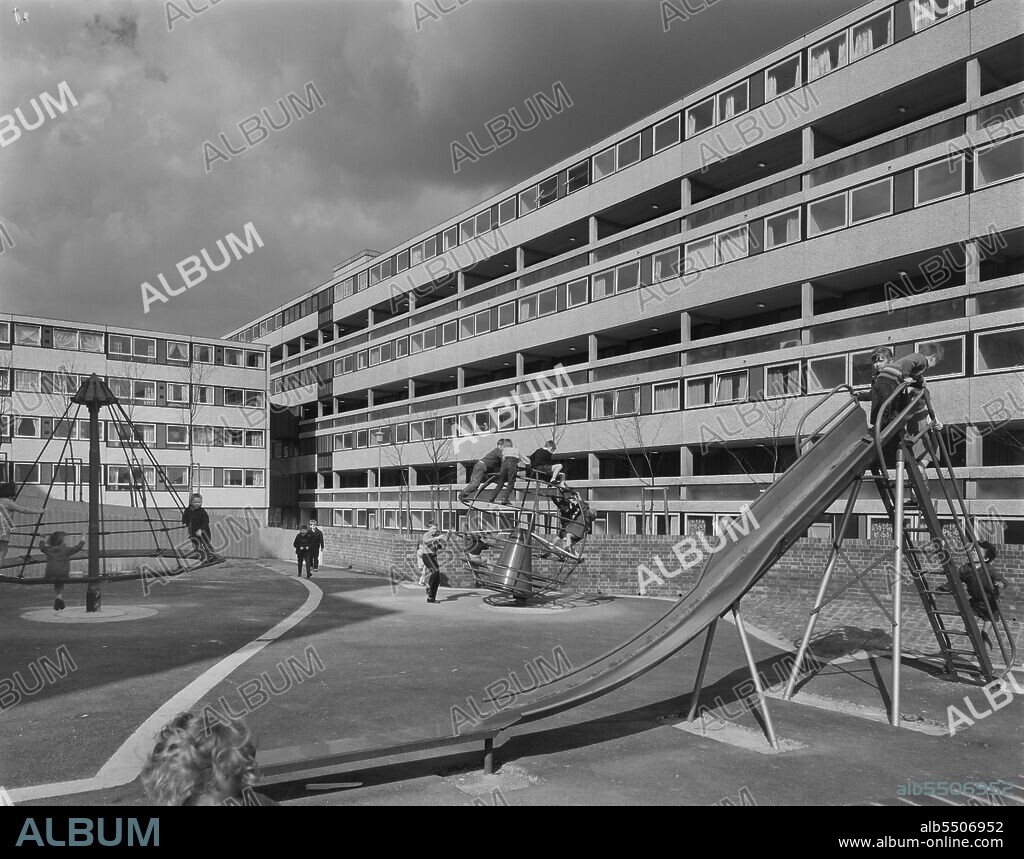 JOHN LAING PLC. Lancashire Hill, Stockport, 28/04/1970. Children playing in one of the playgrounds at Lancashire Hill,  surrounded by flats built using the 12M Jespersen system. Laing's Manchester Region had contracts to build 1200 homes for the County Borough of Stockport. At Lancashire Hill, they had previously built two 22-storey blocks of flats using Storiform, providing 198 homes, and the housing scheme shown in this photo consisting of six linked blocks of four to eight storeys, had been built using Laing's 12M Jespersen system, grouped around three courtyards including two children's playgrounds and a lawned area with flower beds and shrubbery.