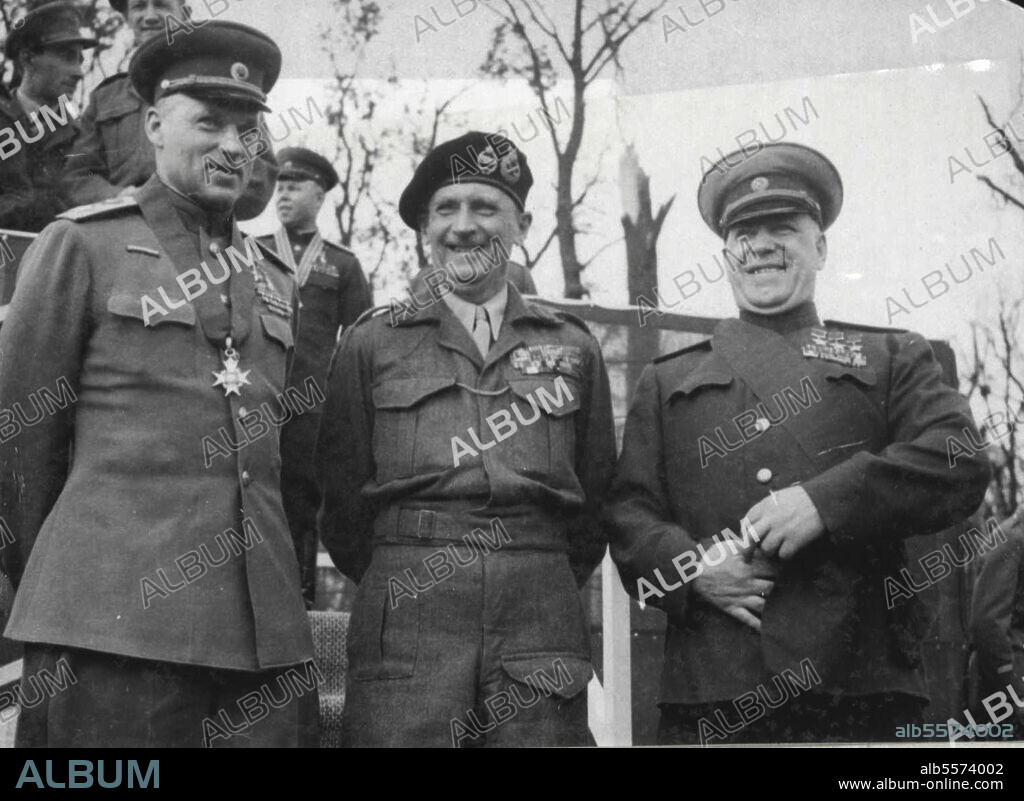 Monty Decorates Red Army Generals - (left to right) - Marshal Rokossovsky, wearing the neck band of the order of knight commander of the bath, Field - Marshal Montgomery, and Marshal Zhukov, wearing the sash of the order of knight grand cross of the order of the bath, on the Rostrom after taking the salute at the March past of Grenadier guards.Field-Marshal Montgomery decorated Marshal Zhukcy with the order of the knight Grand cross of the order of the bath, and Marshal Rokossovsky with knight commander of the bath, at a ceremonial parade in Berli, yesterday, July 12. Montgomery also invested their chiefs of staff. August 27, 1945. (Photo by Associated Press Photo).