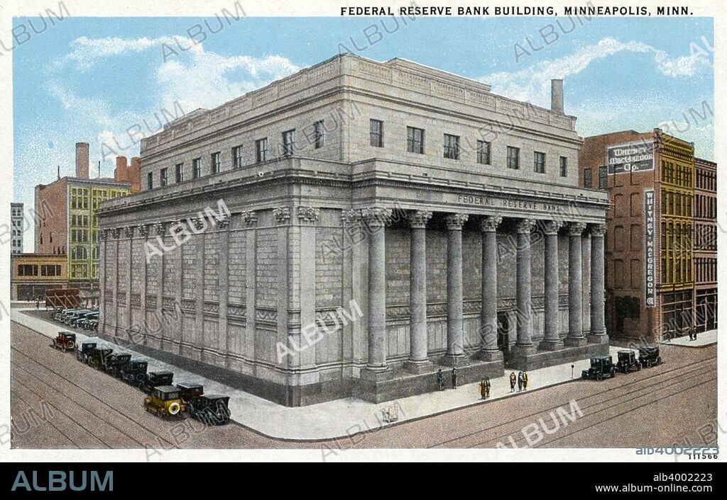 Federal Reserve Bank building, Minneapolis, Minnesota, USA, 1926. Vintage postcard showing the exterior of the Federal Reserve Bank Building. Eight Roman style columns flank the entrance. Vintage cars are parked along the street. Designed by Cass Gilbert, the building was completed in 1915.