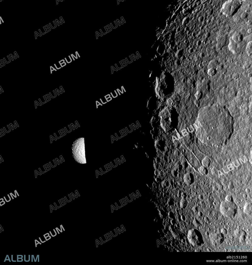Saturn's moon Mimas peeks out from behind the night side of the larger moon Dione in this Cassini image. (Photo by: Universal History Archive/UIG via Getty Images).