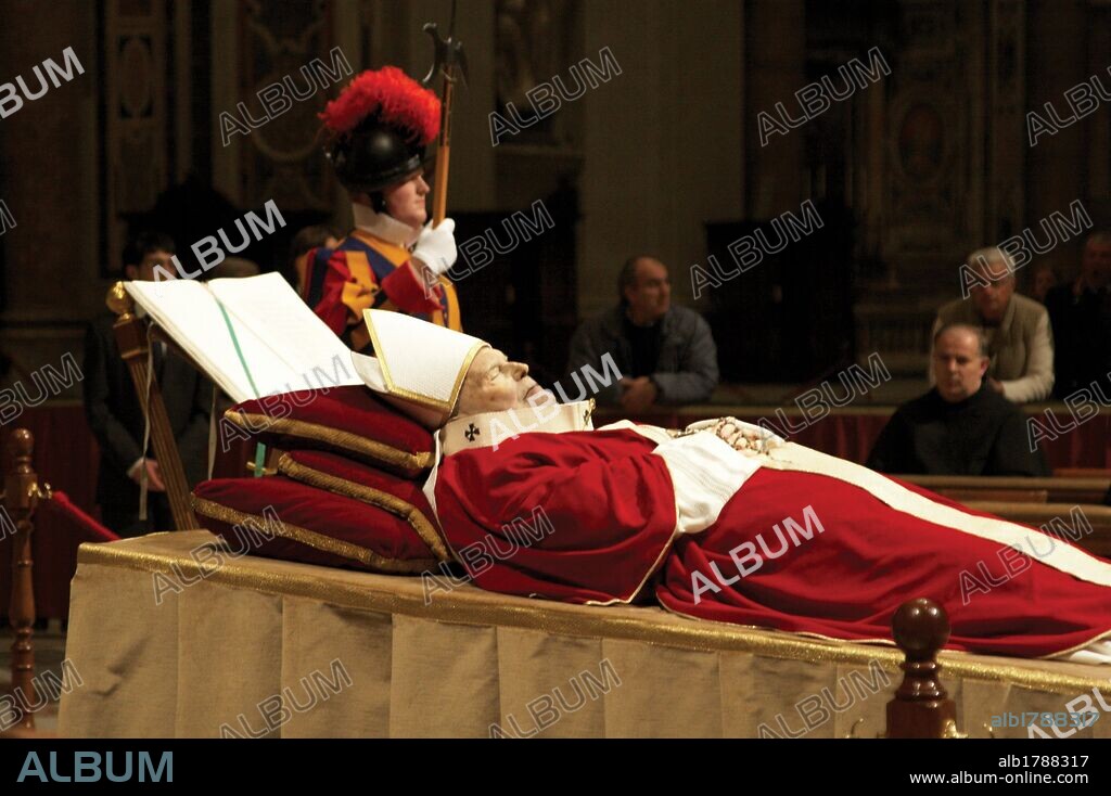 JUAN PABLO II (KAROL JOZEF WOJTYLA), (Wadowice, 1920-Ciudad de El Vaticano, 2005). Papa 264 de la Iglesia católica (1978-2005). Primer Papa no italiano desde Adriano VI en 1522. "CUERPO SIN VIDA DEL PONTIFICE EXPUESTO EN LA NAVE CENTRAL DE LA BASILICA DE SAN PEDRO". Viste de blanco con casulla roja, símbolo de luto en el Vaticano, mitra blanca y báculo. Ciudad de El Vaticano. Italia.