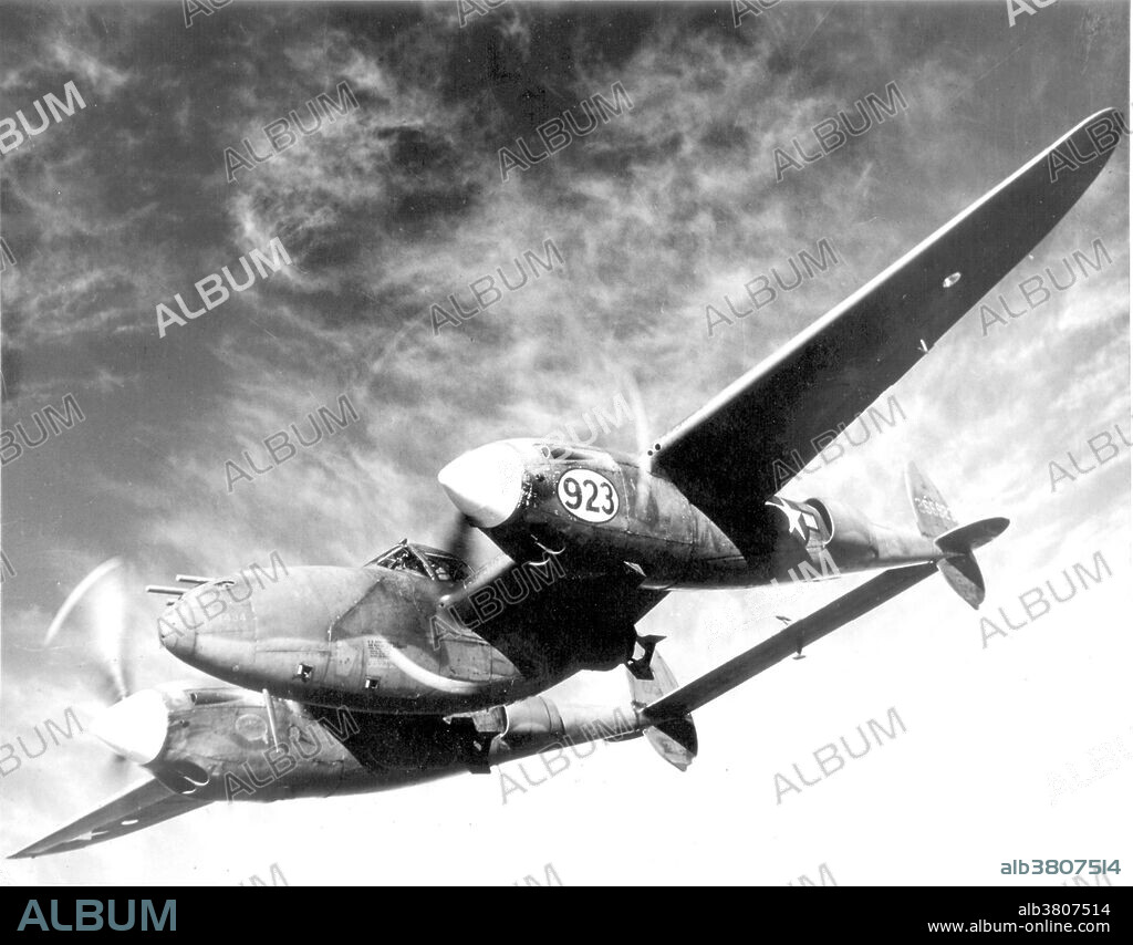 Barely visible beneath the wings of a Lockheed P-38 Lightning are the deadly bombs with which this multi-purpose plane can blast enemy troops, ships and gun emplacements. At the Army Air Forces Tactical Center in Orlando, Florida, the P-38 demonstrated its ability to carry bomb pay loads up to 2,000 pounds. The Lockheed P-38 Lightning was a WWII American propeller driven fighter aircraft. Developed to a United States Army Air Corps requirement, the P-38 had distinctive twin booms and a single, central nacelle containing the cockpit and armament. The P-38 was unusually quiet for a fighter, the exhaust muffled by the turbo-superchargers. It was extremely forgiving, and could be mishandled in many ways, but the rate of roll in the early versions was too slow for it to excel as a dogfighter. The P-38 was the only American fighter aircraft in production throughout American involvement in the war, from Pearl Harbor to Victory over Japan Day.