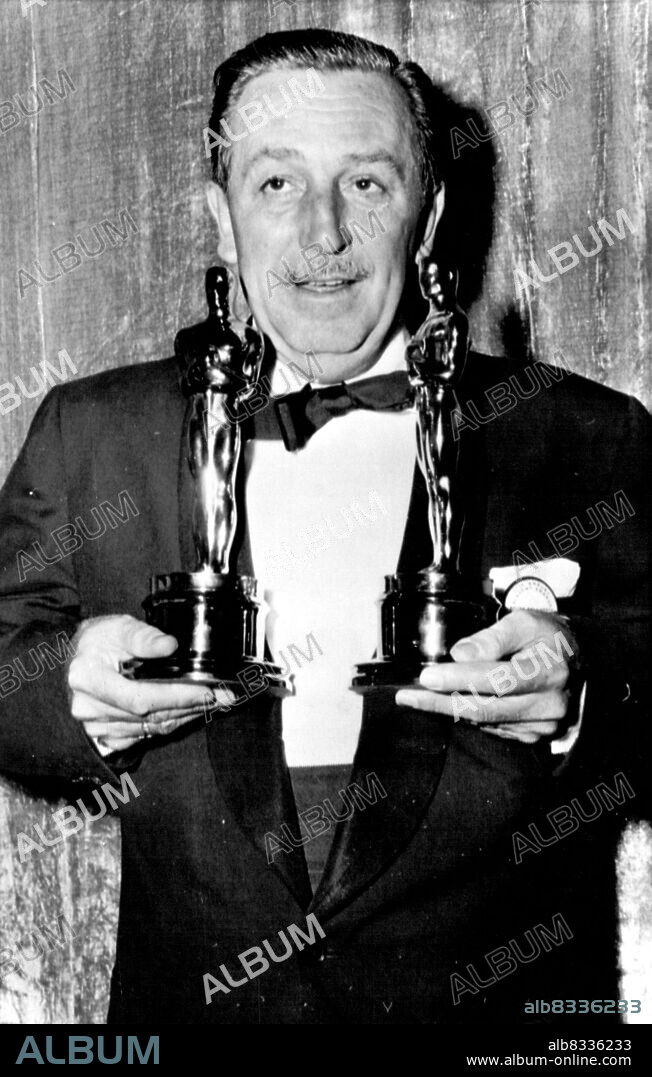 Walt Disney Wins 24th Oscar - Walt Disney, who has won 22 Oscars previously, holds the two he accepted last night at the annual  Academy Awards presentations. As Disney waked off with his second golden statuette master of ceremonies Bob Hope quipped that he noticed the famed carton and nature film creator had arrived at the theater in a truck. The Oscars weigh seven pounds each. Disney won for best special effects and art direction in "20,000 Leagues Under the Sea." March 31, 1955. (Photo by AP Wirephoto).