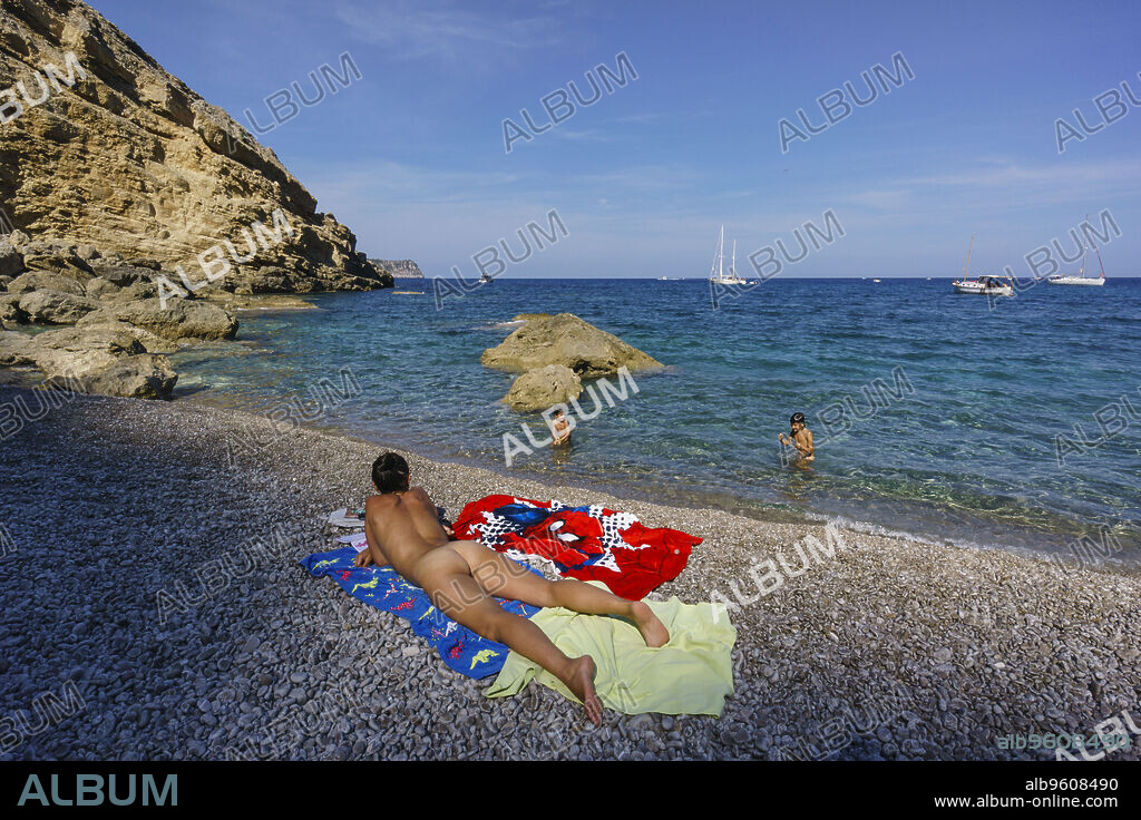 mujer soleandose desnuda,playa de Es Coll Baix, a los pies del Puig de Sa Talaia, Alcudia,islas baleares, Spain.