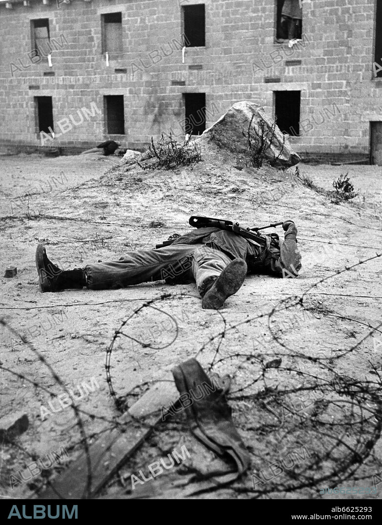 A soldier of the US army acts as a soldier killed in action during an exercise on the 27th of December in 1961 in the ghost village "Parks Range" in Berlin-Lichterfelde, which was especially built for army training. 27/12/1961