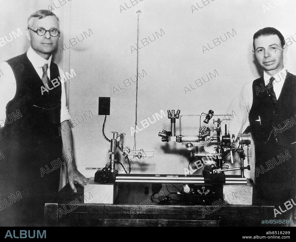 Orig. bildtext... SCIENTISTS TEST WORLD'S LARGEST MICROSCOPE Dr. Arthur Isaac Kendall (left) of Northwestern University, and Dr. Royal R. Rife, of the Rife Research Laboratory in San Diego, Cal., with the world's largest microscope, during tests before medical men and other scientists at Pasadena, Cal. It is capable of a magnification of between 5,000 and 17,000 diameters, and is the invention of Dr. Rife. This new discovery promises to supply the missing link in bacteriological science, science forms of bacteri never before beheld by men were made visible. Six quartz lenses are used. Another unique feature is that the object instead of being seen in reverse focus as with present instruments, is viewed in its true prospective. Anm. CD164 persons: Royal Rife ;Arthur Isaac Kendall sites: USA.