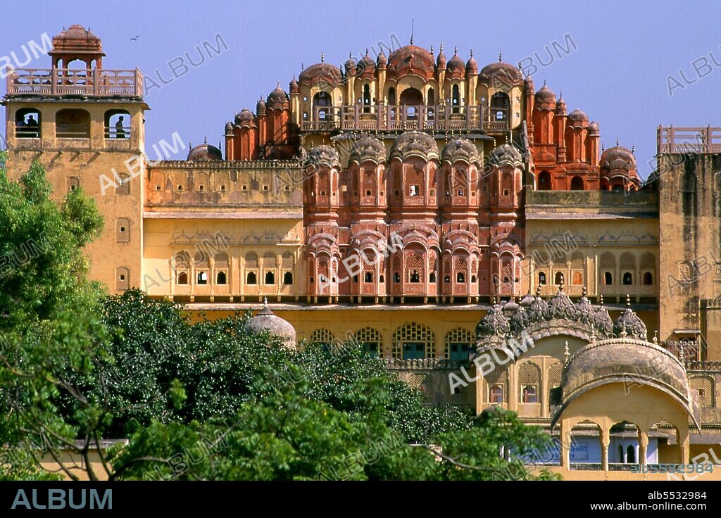 The Hawa Mahal was built in 1799 by Maharaja Sawai Pratap Singh, and designed by Lal Chand Ustad in the form of the crown of Krishna, the Hindu god. Jaipur is the capital and largest city of the Indian state of Rajasthan. It was founded on 18 November 1727 by Maharaja Sawai Jai Singh II, the ruler of Amber, after whom the city was named. The city today has a population of 3.1 million. Jaipur is known as the Pink City of India. The city is remarkable among pre-modern Indian cities for the width and regularity of its streets which are laid out into six sectors separated by broad streets 34 m (111 ft) wide. The urban quarters are further divided by networks of gridded streets. Five quarters wrap around the east, south, and west sides of a central palace quarter, with a sixth quarter immediately to the east. The Palace quarter encloses the sprawling Hawa Mahal palace complex, formal gardens, and a small lake. Nahargarh Fort, which was the residence of the King Sawai Jai Singh II, crowns the hill in the northwest corner of the old city. The observatory, Jantar Mantar, is a World Heritage Site.