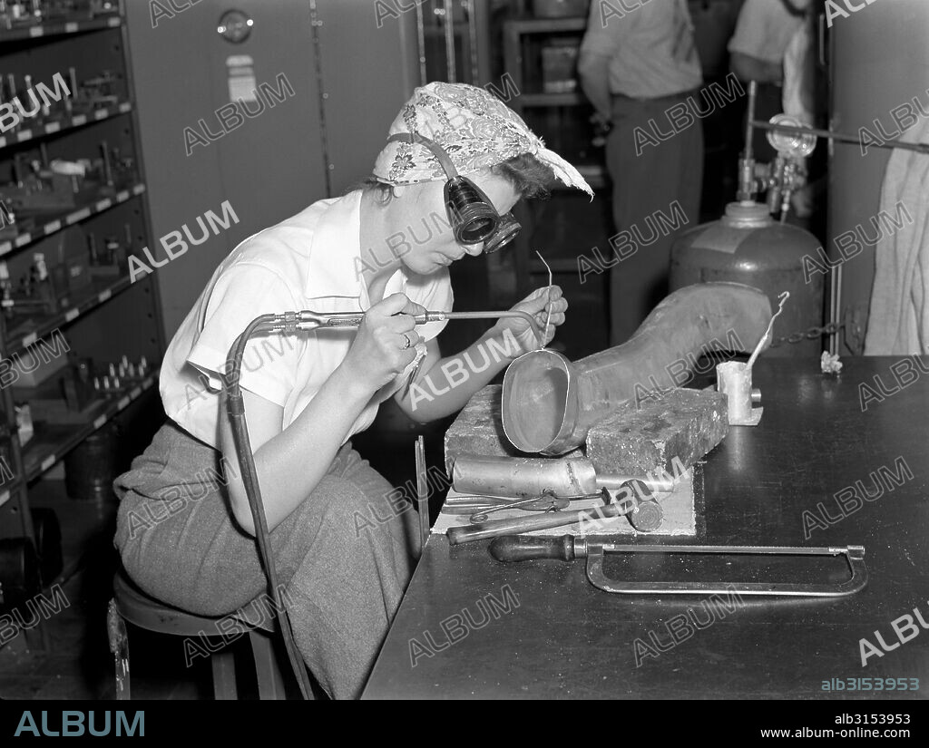 Ypsilanti, Michigan:   July, 1942. Production at the Ford Willow Run bomber plant. Steady of eye and hand, women workers at the great Willow Run bomber plant are among those throughout the country who are relieving serious shortages of skilled workers by doing such semi-skilled jobs as the one shown here. She's welding parts of the cooling system to the supercharger.