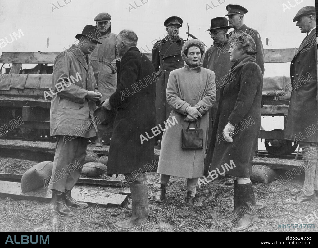 Duke And Duchess Of Gloucester Tour Flooded Areas Of Fenland:Inspect Earith Gap In Banks Of The River Ouse -- The Duke and Duchess of Gloucester photographed during their inspection of the Earith Gap. Both wearing oilskins. The Duke of Gloucester is talking to a member of the Ouse Catchment Board.The Duke and Duchess of Gloucester inspected the flooded areas bear Ely, Cambridgeshire, and inspected the Earith Gap,in the banks of the River Ouse, at Bluntisham, where flood water poured through and inundated many square miles of the Fenland. district,causing  millions  of pounds worth of damage to the surrounding countryside.Troops have fought for weeks stem the breach in the banks, and eventually  the Gap was closed by placing Neptune tanks in position against  the floodwater. March 30, 1947.