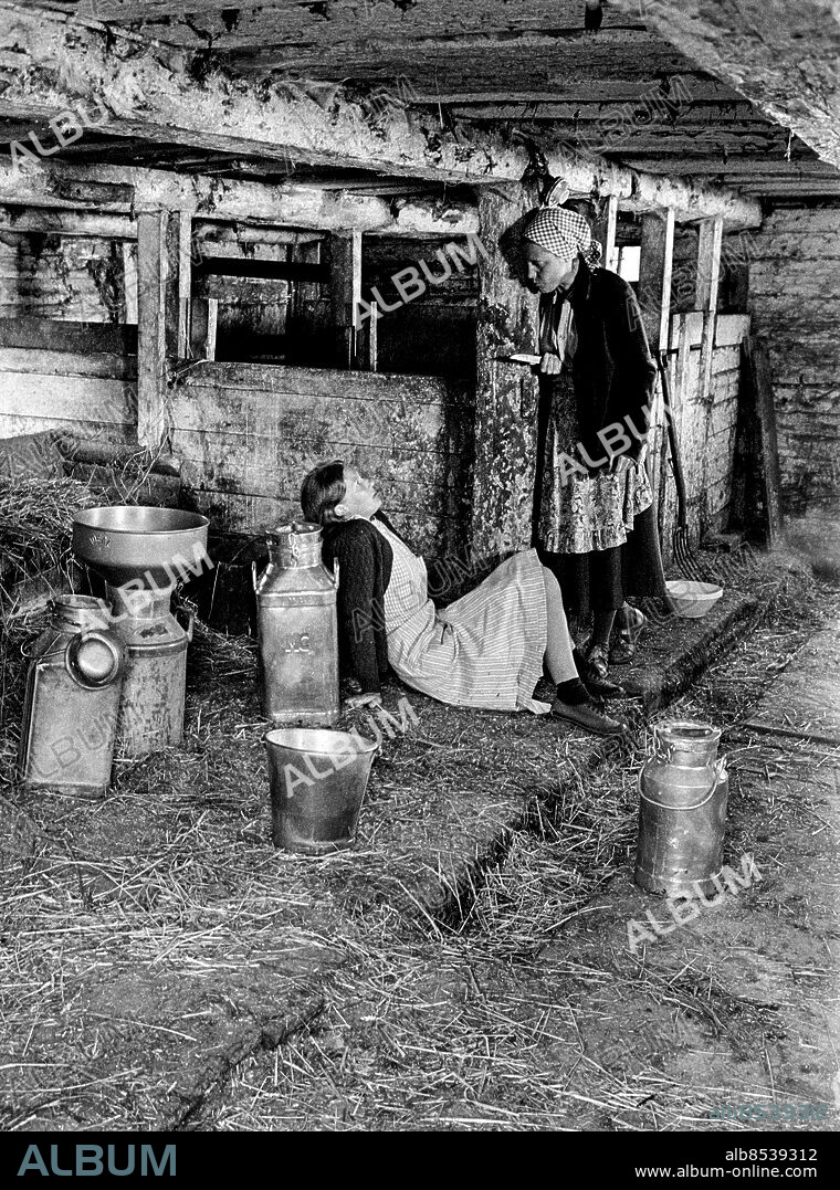 1970-07.. DEN YTTERSTA DAGEN. TV-pjäs av Stig Dagerman i regi av Per Sjöstrand.. Sänt första gången 1970-09-27.. Här ses skådespelerskorna Claire Wikholm (tv), som Siv, och Mona Andersson, som Tora, i lagårn.. Foto: Bo-Aje Mellin / RiR / SVT / Kod: 5600. Bild och reportage publ. i RiR 40/70 sid. 35.. RiR 19891 sv/v neg  . Mjölkkannor Knivar.