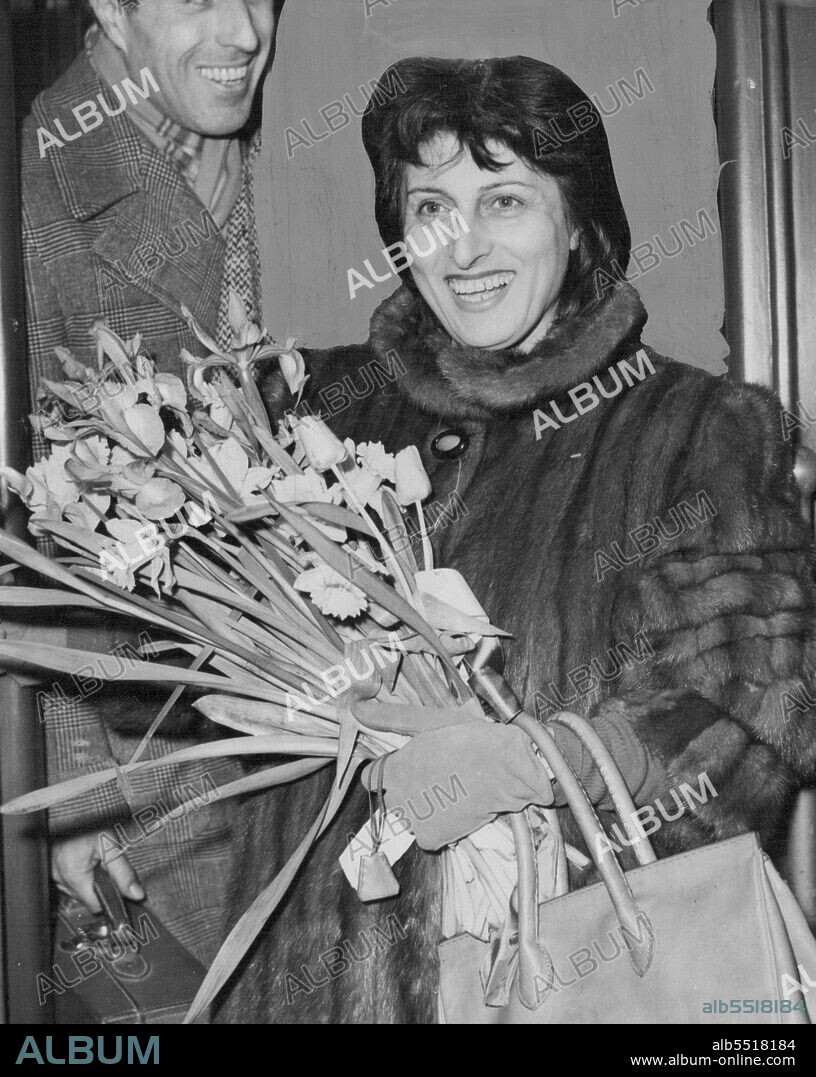 Here For Double Purpose.Wearing fur coat and carrying flowers, Anna Magnani, Italian film star of "Open City" fams, on arrival at Victoria Station, London tonight (Thursday). Purpose of her visit is two-fold she is to attend the premiere of her new picture "Angelina" at the Academy Cinema and to see something of London's postwar rehousing, in which she is keenly interested. Most of her spare time is spent studying human problems, particularly the living conditions in Italy. She hopes to take back some useful tips with her. March 17, 1949.