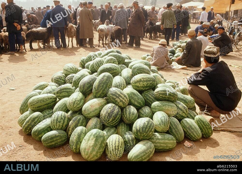 Völkerkunde / China.-Auf dem großen Sonntagsmarkt in Kashgar / Kashi (Autonome Region Xinjiang, VR China): Händler mit Melonen.-Foto, undatiert.
