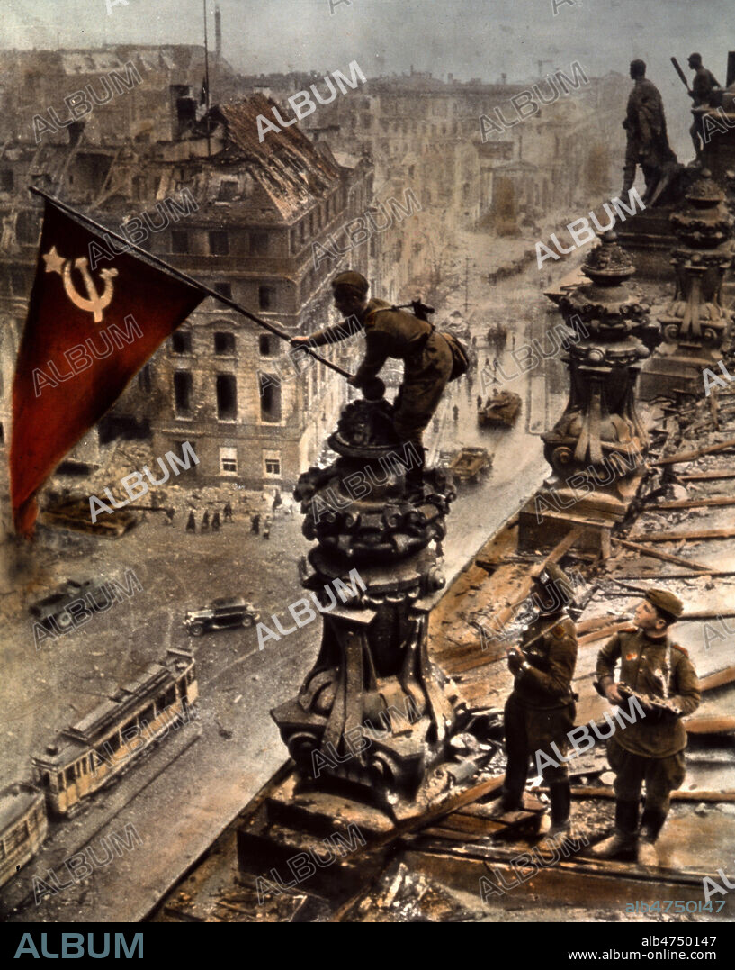 Allemagne nazie, 2eme guerre mondiale : Un soldat de l'Armee rouge y plante le drapeau de l'URSS le 2 mai 1945. Une des photos mythiques de la 2de guerre mondiale 'le drapeau sovietique flottant sur le Reischtag' par Evgueni KHALDEI photographe officiel du regime sovietique, agence de presse TASS. Sur l'epreuve ou le soldat du milieu tenait la jambe du porteur du drapeau, on pouvait voir qu'il portait 2 montres, une a chaque poignet, preuve de pillage. La photo fut donc retouchee. Credit NBL/KHARBINE TAPABOR.