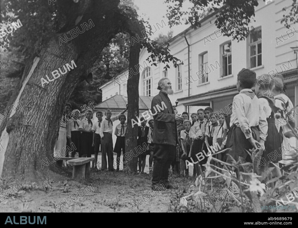 Count Lev Nikolayevich Tolstoy (1828-1910), also known as Leo Tolstoy, Russian novelist, short story writer, philosopher and playwright. Photo Shows: Tolstoy's coachman Ivan V. Yegorov, with a visiting group of young pioneers at the Tolstoy Museum at Yasmaya Polyana. Supplied By: SCRSS - Society for Co-operation in Russian & Soviet Studies.
