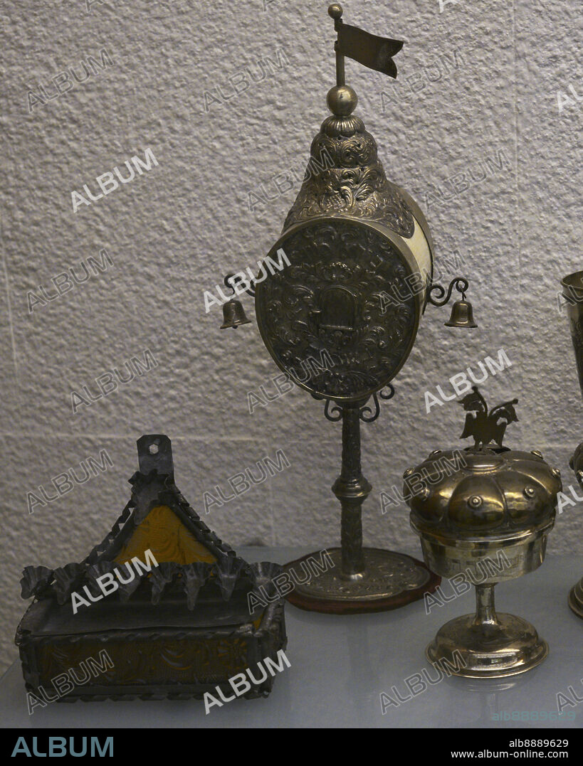Izquierda.: lámpara para la fiesta de las Luces (Hanuká). Finales del siglo XIX. Latón y cristal. Procedente de Djerba (Túnez). Centro: perfumador para la ceremonia de Habdalah. Siglos XIX-XX. Plata y marfil, inscripciones en hebreo. Procedente de Centroeuropa. Derecha: copa de quidús para la fiesta del sábado. Incorpora tapa con recipiente para especias, con inscripciones hebreas. Siglo XX. Plata. Procedente de Centroeuropa. Museo Sefardí. Toledo. Castilla-La Mancha. España.
