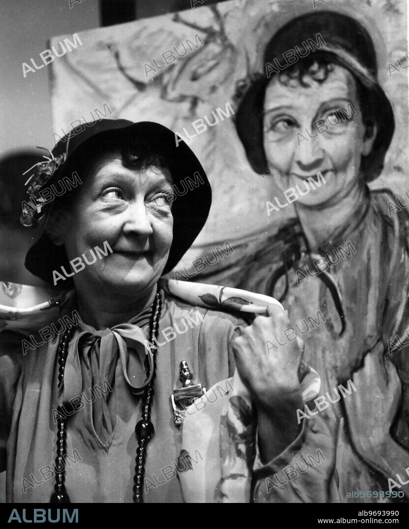 To commemorate their wonderful performances in Philip King and Falkland Cary 's Naval farce " Watch it, Sailor ! " , Toby Rowland , has asked the fashionable portrait painter , Alex Portner , to paint the three stars , Kathleen Harrison , Cyril Smith and Esma Cannon for the foyer , in the characters they portray in the play . Photo shows: Esma Cannon poses as Aunt Edie (the character in the play ) beside the portrait painted by artist Alex Portner . 12 October 1960.