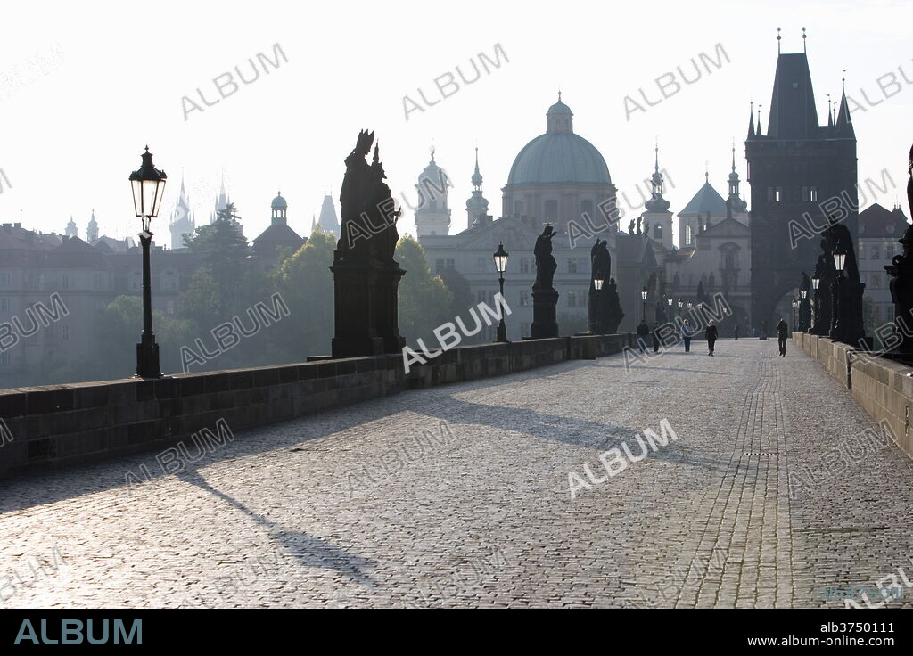 Statues on Charles Bridge, UNESCO World Heritage Site, with the dome of the Church of St. Francis and Old Town Bridge Tower in the background, Old Town, Prague, Czech Republic, Europe.