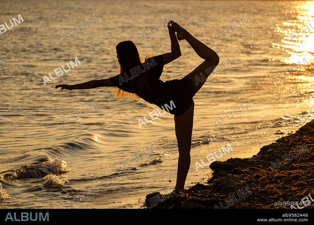 mujer joven practicando yoga, playa de Sa Rapita, Campos, Mallorca, balearic islands, Spain.