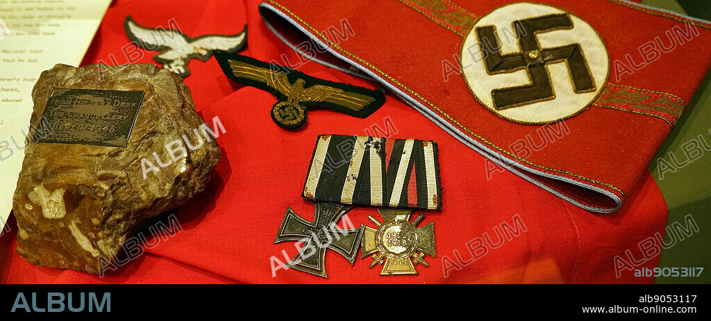 German Nazi armband, and medals as well as other insignia captured during the liberation of France in World war two. section from of Adolf Hitler's desk. Removed from the Fuhrer Bunker beneath the Chancellery in Berlin, by Lt Col Richard Broad MC, Seaforth Highlanders, The desk had been broken in pieces by Russian soldiers in May 1945, in World war two.