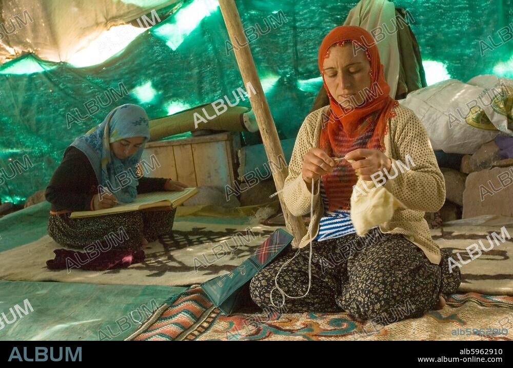 Asien, Türkei, Provinz Bingöl, beim Stamm der Beritan-Nomaden auf einer Hochweide in den Serafettin-Bergen östlich des Provinzstädchen Karliova, Mädchen liest im Koran und Frau mit Handarbeit.