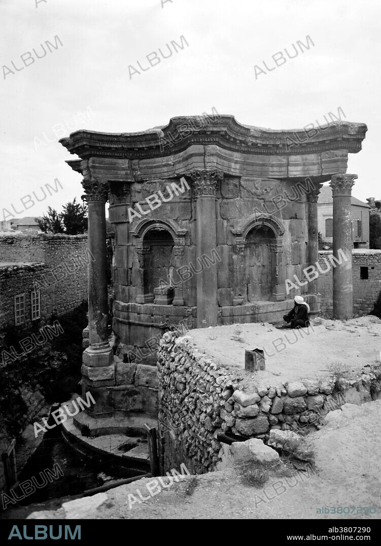 The Temple of Venus was added under Septimius Severus in the early 3rd century but destroyed under Constantine, who raised a basilica in its place. It lies about 150 yards rom the southeast corner of the Temple of Bacchus. It was known in the 19th century as El Barbara or Barbarat el-Atikah (St Barbara's), having been used as a Greek Orthodox church into the 18th century. Baalbek is a town in the Beqaa Valley of Lebanon situated east of the Litani River. After Alexander the Great conquered the Near East in 334 BC, the existing settlement was named Heliopolis. The city retained its religious function during Greco-Roman times, when the sanctuary of the Heliopolitan Jupiter-Baal was a pilgrimage site, and one of the largest sanctuaries in the empire. Starting in the last quarter of the 1st century BC (reign of Augustus) and over a period of two centuries (reign of Philip the Arab), the Romans had built a temple complex in Baalbek consisting of three temples: Jupiter, Bacchus and Venus. On a nearby hill, they built a fourth temple dedicated to Mercury. Photographed by the American Colony (Jerusalem) Photo Department, 1936.