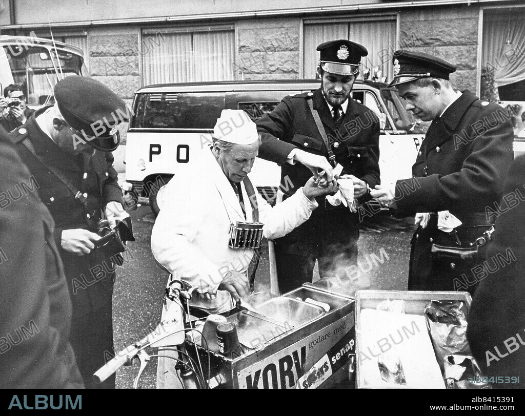 STOCKHOLM 1968-05-27. Varsågod nästa! Att vakta revolutionärer ger aptit. En polisman letar efter en 25-öring för att hinna handla innan korven är slut under Kårhusockupationen i Stockholm.. Foto: Dagens Nyheter / TT / Kod: 192. ** SvD OUT **.