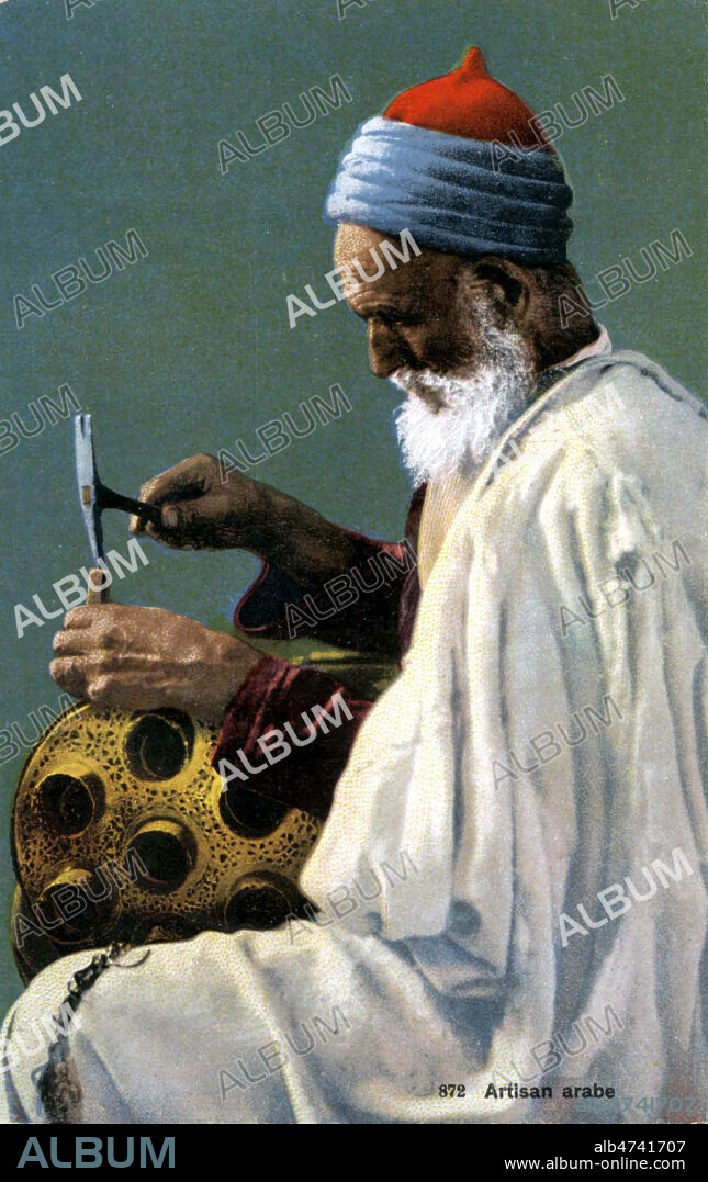 'Artisan arabe'. Ferblantier travaillant un ustensile a Tunis, en Tunisie. Photographie anonyme pour une carte postale de 1908. Credit : Jewish Memories / Kharbine-Tapabor.
