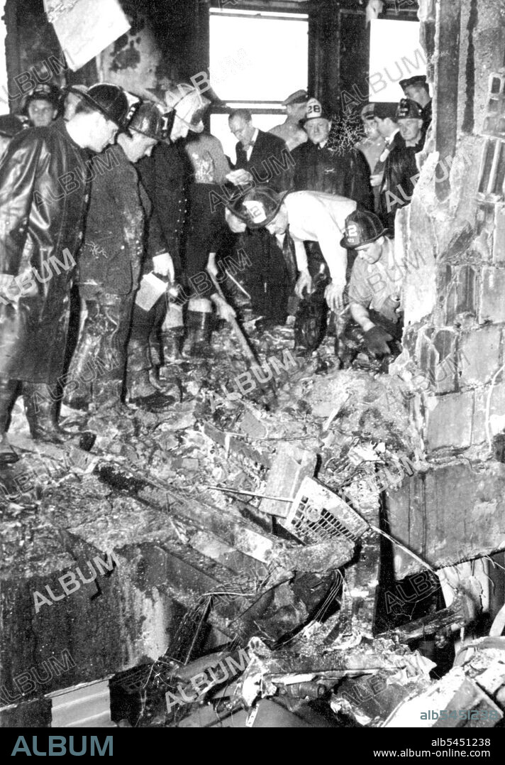 Search For Bodies Of Crash Victims -- Firemen dig through wreckage of the plane that crashed into the upper part of the Empire State Building in New York, July 28th, searching for bodies of victims of the crash. This scene is on the 79th floor, looking through the elevator shaft into an office. Hote at upper left was made by the plane. July 28, 1945. (Photo by Associated Press Photo).