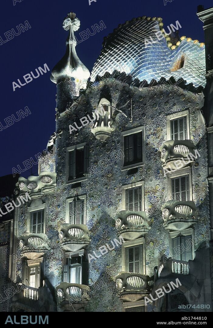 ARTE S. XIX-MODERNISMO. ESPAÑA. CASA BATLLO (1904-1906). GAUDI, Antoni (Reus 1852-Barcelona 1926). Vista nocturna de la fachada, ondulante de cerámica. La cubierta tiene forma de armazón de dragón. Torre con cúpula de cebolla y cruz de cuatro brazos. BARCELONA. Cataluña.