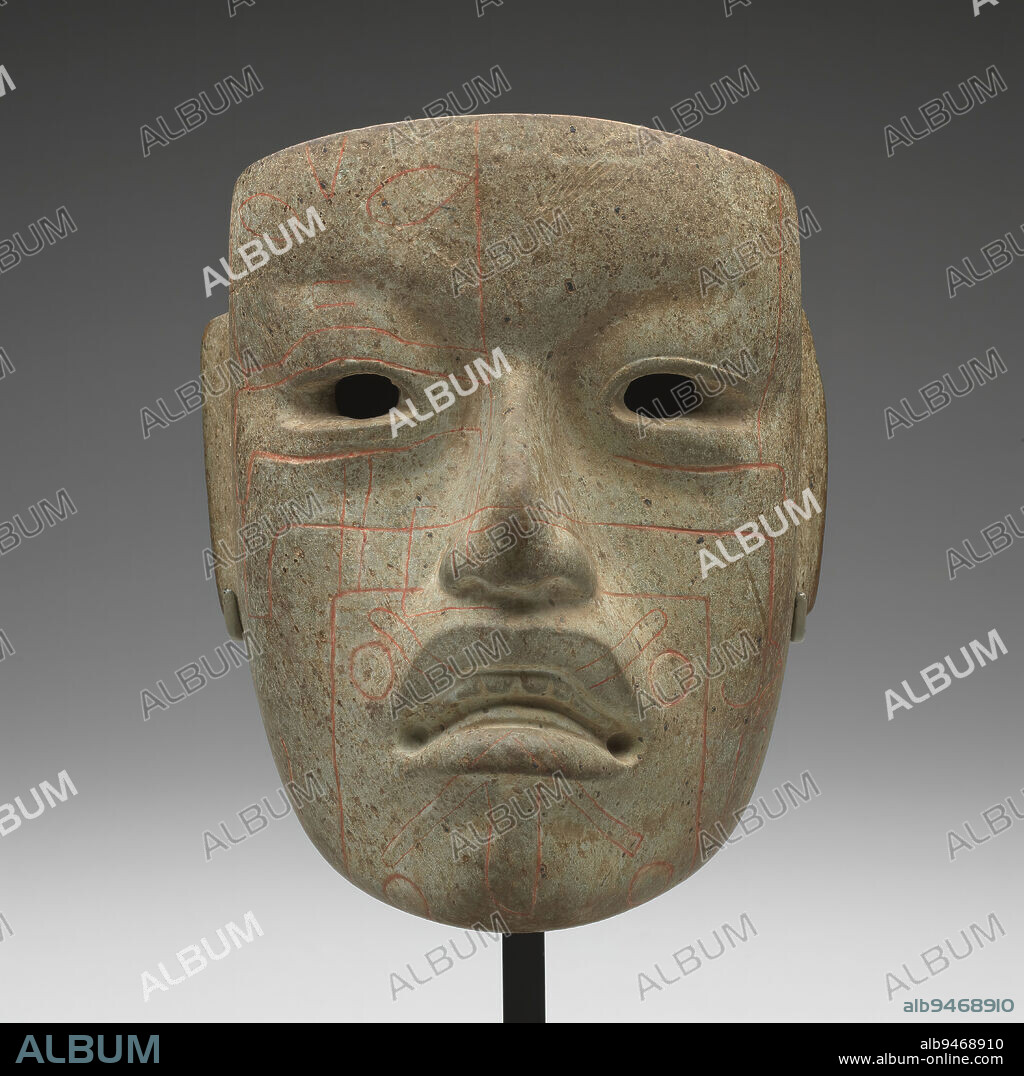 Mask, c. 900-300 BCE, 6 7/8 x 5 9/16 x 3 1/4 in. (17.46 x 14.13 x 8.26 cm), Jadeite, cinnabar, Mexico, 9th-3rd century BCE, This mask was created about 3000 years ago, perhaps as a portrait of a leader among the Olmec people of Mesoamerica (present-day southern Mexico). It was likely reserved for ceremonial use. An artist sculpted it from jadeite, then carved lines and highlighted them with a red mineral powder of mercury sulfide (cinnabar). These lines may replicate face paint or tattooing. The rare materials and symbolic designs, like the supernatural human-jaguar whose face hovers above the right eye, reflect the ruler's religious and political power.
