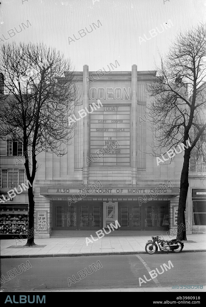 The Odeon, Haverstock Hill, Hampstead, London, c1934. Entrance front of the Odeon. Of the art deco style in a strong geomtrical design. It was designed by    TP Bennett and Sons, and opened in 1934. The main attraction is 'Now and Forever' with Gary Cooper and Shirley Temple.