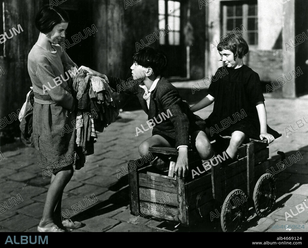 Deux enfants dans une caisse a savon. Photographie du film 'Menilmontant', realise par Rene GUISSART (1888-1960) en 1936, d'apres Roger DEVIGNE. Credit : Collection KHARBINE-TAPABOR.