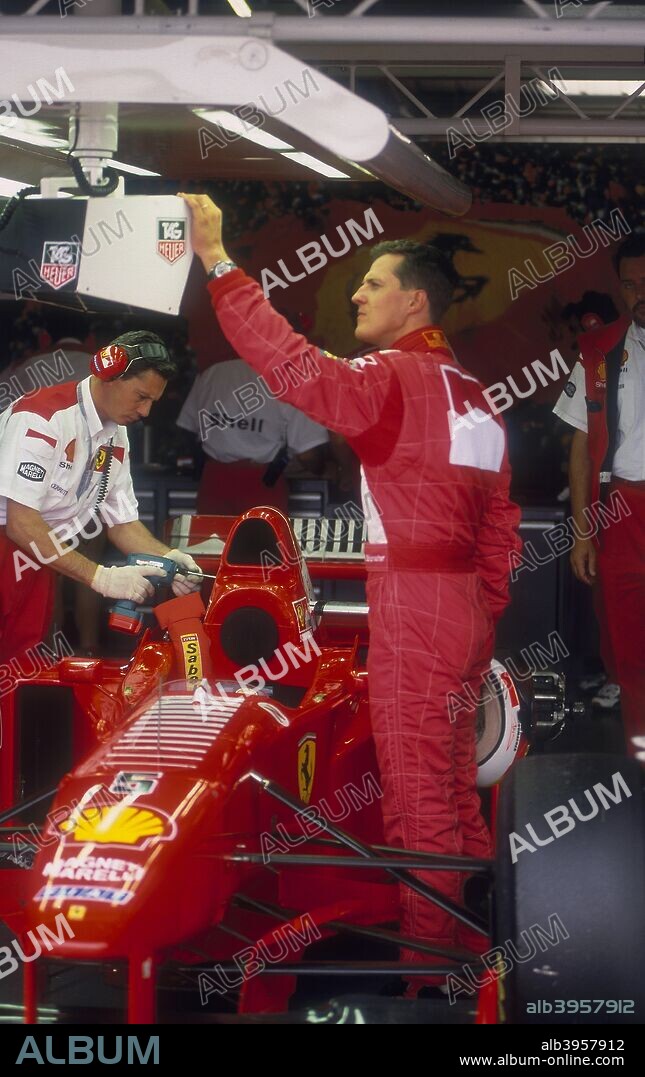 Michael Schumacher with Ferrari, British Grand Prix, Silverstone, Northamptonshire, 1997. When winning his 52nd Grand Prix in 2001, Michael Schumacher became the most successful Formula 1 driver ever in terms of race wins. After a meteoric career in karting and junior formulae, Schumacher entered Formula 1 in 1991 with Jordan, but quickly switched acrimoniously to the more powerful Benetton team, with whom he won his first two World Championships in 1994 and 1995. He then made a lucrative move to Ferrari, and such was his talent that he was able to remain competitive despite the relatively inferior performance and reliability of the car. However, when Ferrari were able to provide him with an improved car, Schumacher repaid them with the 2000 Drivers' title, the first for the team since 1979, repeating the performance in each of the following four seasons. Schumacher's driving brilliance, particularly in the wet, is matched by his ruthlessness, with his single-minded, intimidatory approach to racing having seen him involved in frequent controversy.