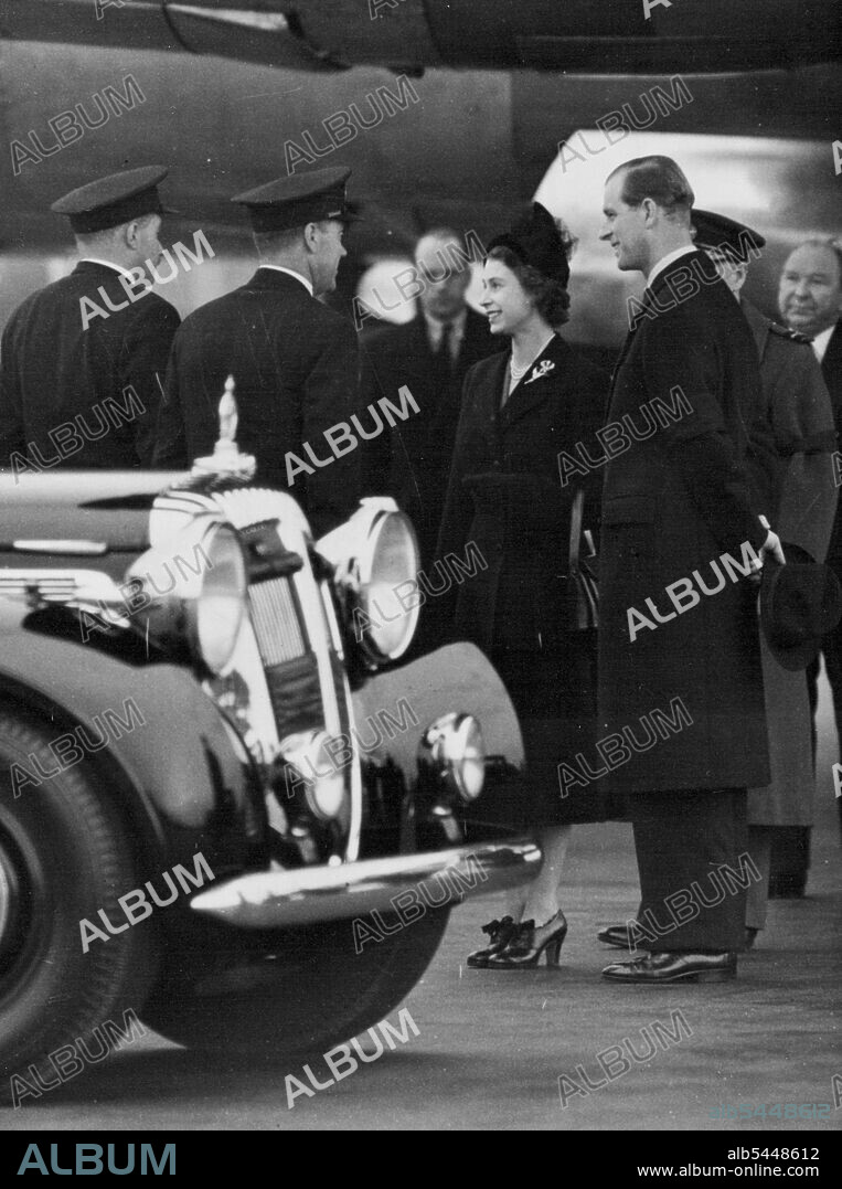 The Queen Arrives Home - The Queen and Prince Philip standing by their car before leaving for Clarence House. Her Majesty Queen Elizabeth II Arrived at London Airport this afternoon completing a 4217 mile flight from Nairobi, Kenya. Her Aircraft the "Atalanta" Had Made one stop for Refueling at the R.A.F. Airfield of El Adem in the Lybian Desert. The Royal Plane Arrived at EL Adem at 6.2 A.M. This morning but only stopped for 58 Minutes. The Queen Drove straight to Clarence house from the airfield over which building the Royal standard was Hoisted for the first Time. Letter Telegrams and messages of condolence continue to pour into Buckingham palace from all over the world. This evening at 9-P.M. The Prime Minister will Broadcast to the Nation. February 7, 1952. (Photo by Paul Popper).