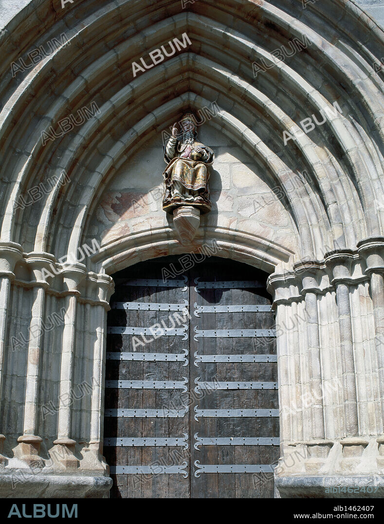 Gothic art. Spain. Church of St. John the Baptist. Door with archeries of pointed archs and seated sculpture of a saint in the tympanum. Mondragon. Province of Guipuzcoa. Basque Country.