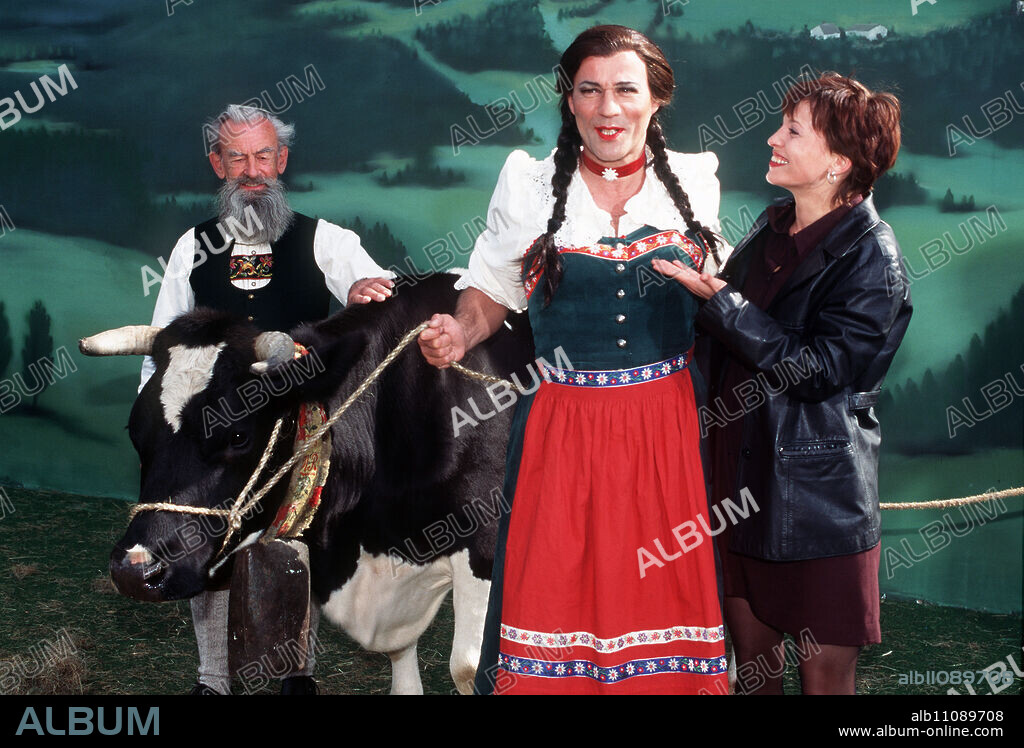 FAUST - Ulrike (STEPHANIE PHILIPP) can't help but laugh as Faust (HEINER LAUTERBACH, M.) marches towards her in a wig and women's clothing. Left: extra. Director: Mark Schlichter aka. Powerslide / Headline: FAUST / BRD 1996.