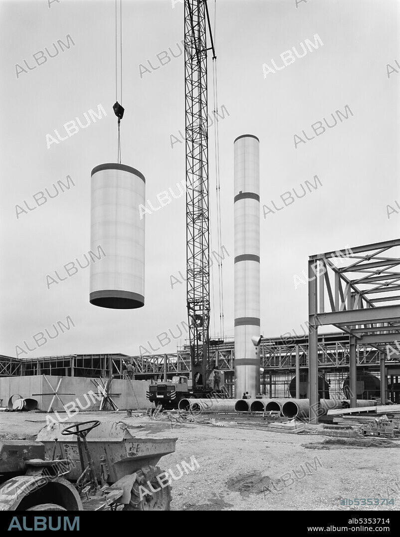 JOHN LAING PLC. A section of the 200ft tall chimney being raised by crane at the new Courage Brewery site. This image was catalogued as part of the Breaking New Ground Project in partnership with the John Laing Charitable Trust in 2019-20.