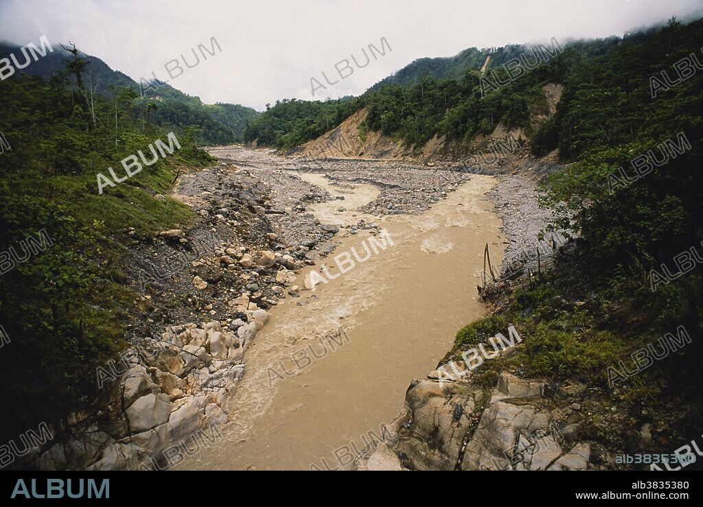 Sediment-laden Ok Tedi River downstream of the Ok Tedi heavy metal mine in Papua New Guinea.  The mine earns foreign exchange for developing Papua New Guinea, but it has also caused environmental damage and disruption for people that depend on the Ok Tedi and Fly Rivers.